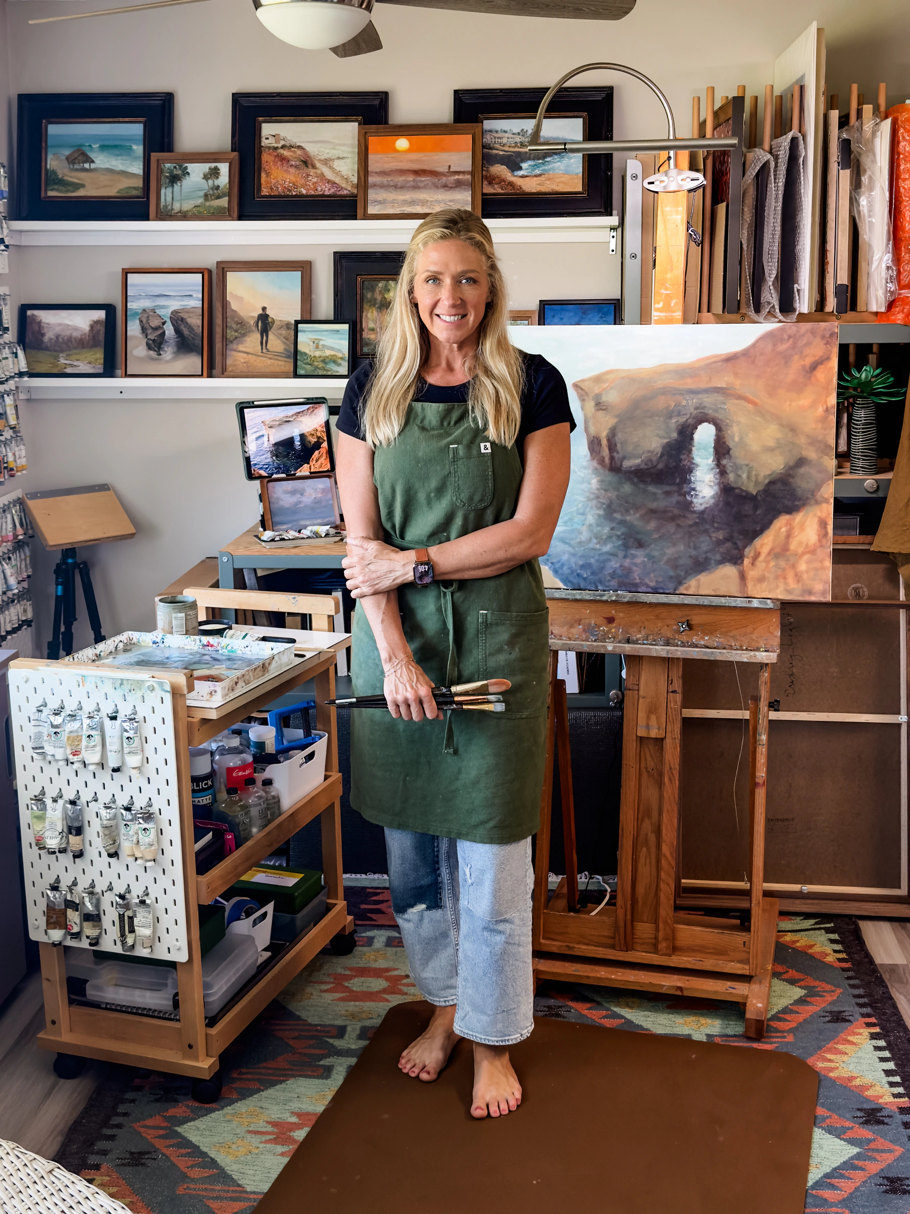 Jill Weeks Smith in her studio beside a coastal arch painting