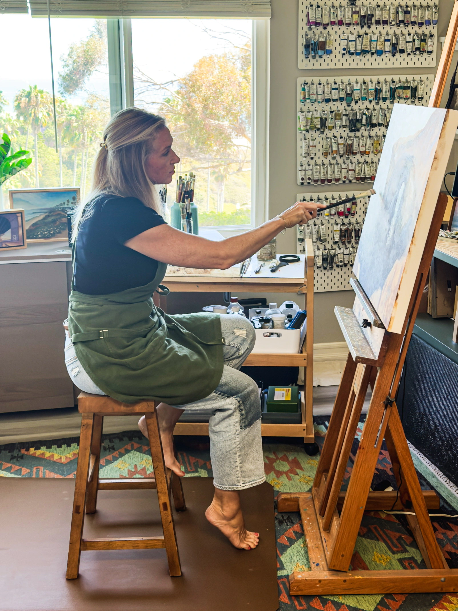 Jill Weeks Smith painting at an easel in her studio