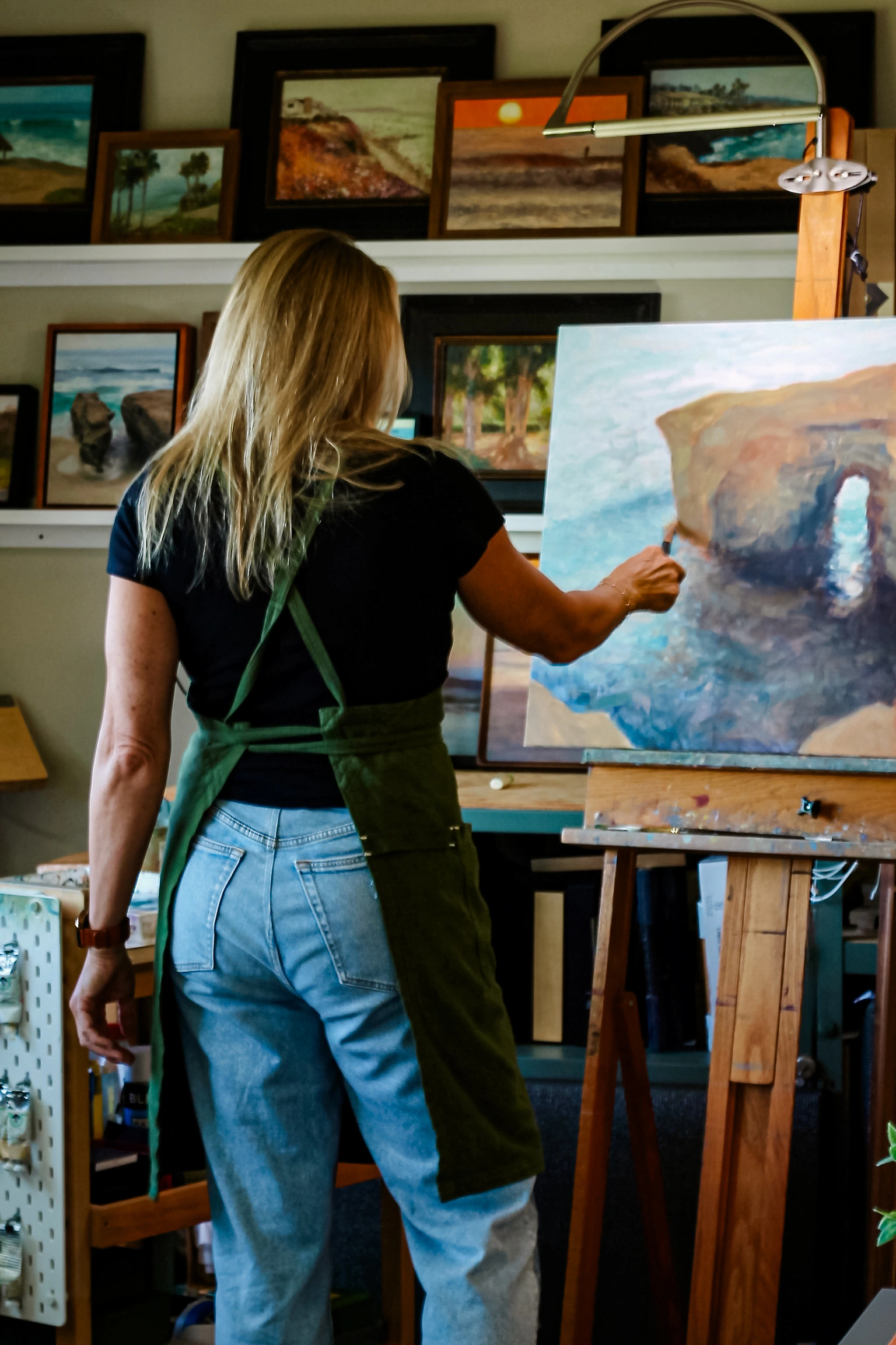 Jill Weeks Smith painting a coastal arch from behind her easel